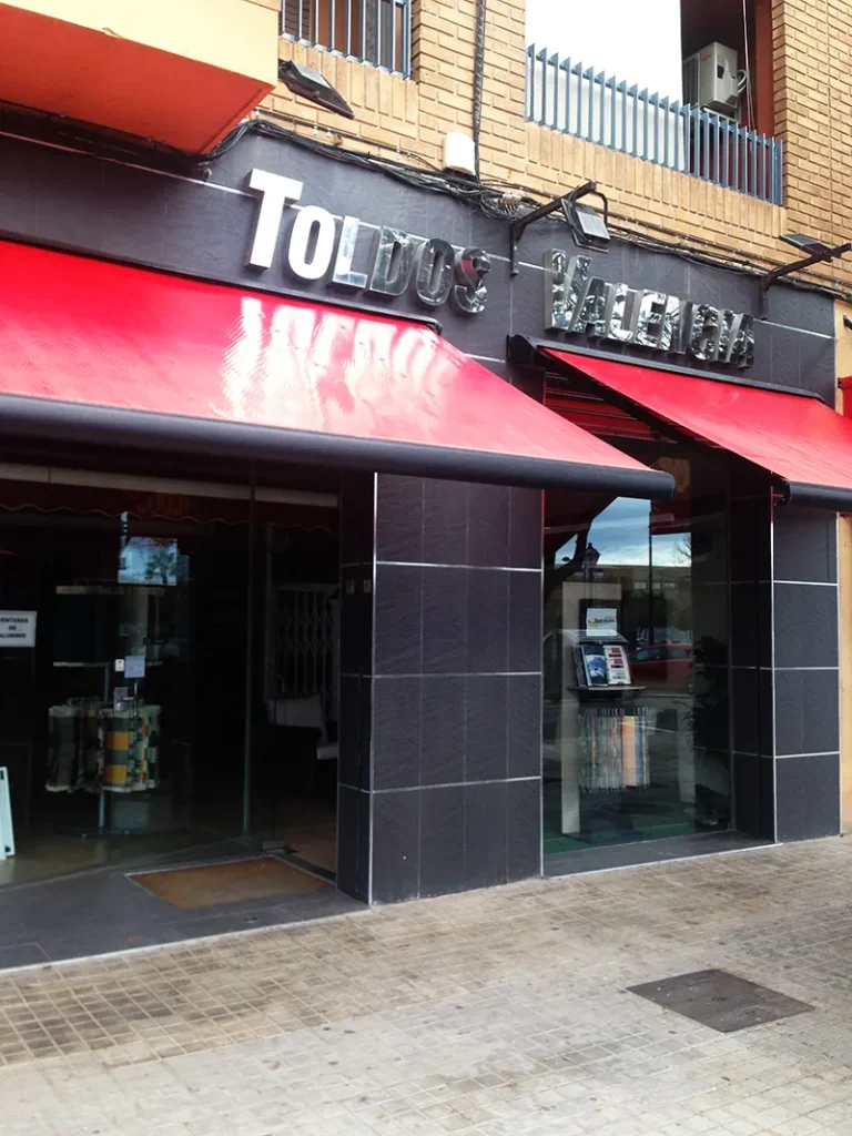 Toldo cofre motorizado para protección solar en local comercial.