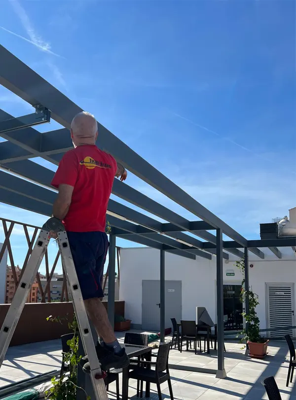 Técnico profesional de Toldos Valencia tomando medidas en una terraza para un proyecto de instalación de toldo a medida.
